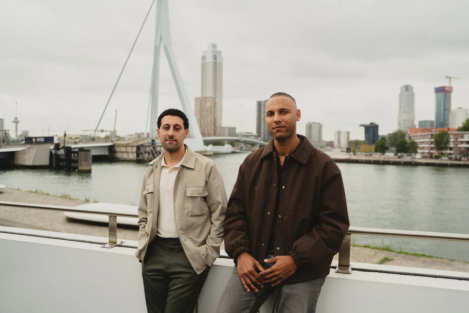Seleman Arefi and Luciano Currie, the founders of WAINUT, by the water in Rotterdam with the Erasmus Bridge in the background